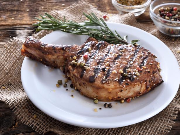 Juicy grilled pork chop with spices on a white plate