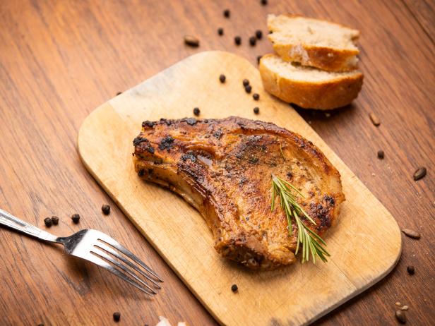 Grilled pork chop with spices and bred on wooden background