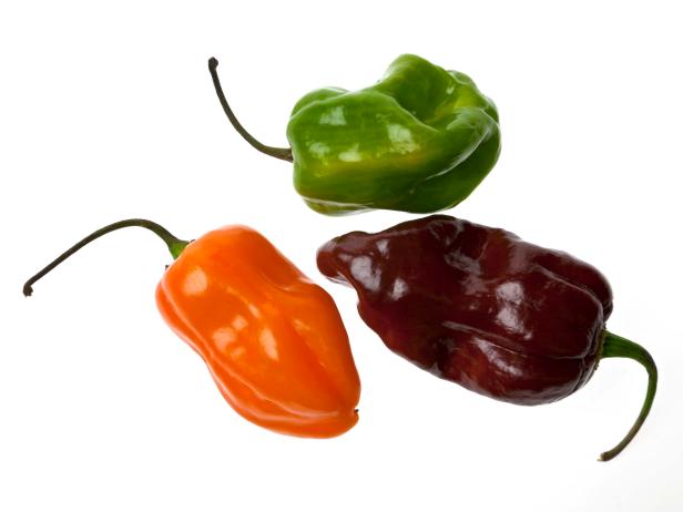 "Three varieties of habaAero peppers - orange, green and brown"