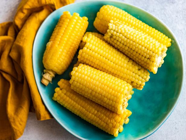 Boiled corn vegetable served on the plate with salt on concrete background