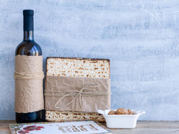 Pack of matzah or matza and red kosher wine on a vintage background. Jewish Passover holiday composition