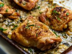 Crispy baked chicken thighs in a creamy spinach artichoke heart sauce