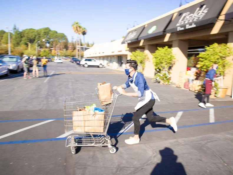 Chef Michael rushing back to his station with a cart full of groceries, as seen on Supermarket Stakeout, Season 3.