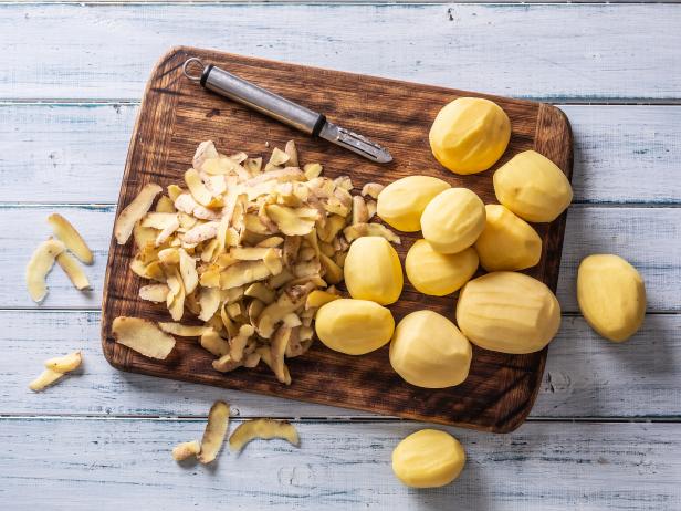 Peeled potatoes on a cutting board - top of view.