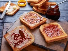 savory toasts for breakfast with butter vegemite - healthy food spread made from leftover brewers yeast extract with vegetables and spices, view from above, close-up
