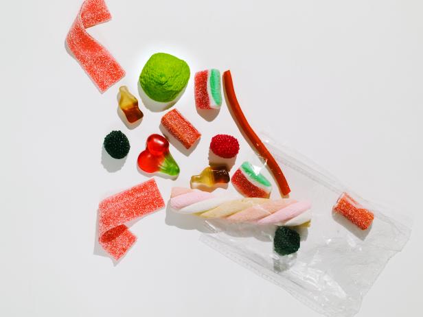 Close-up view of an open plastic bag of candy on a white background. Unhealthy food. Ideal product to give as a gift at a birthday party.