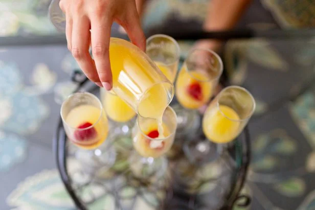 Orange juice and champagne mixed in a glass to make a mimosa with strawberries