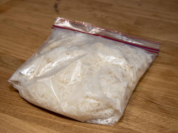 A bag of frozen white rice on a wooden kitchen work top