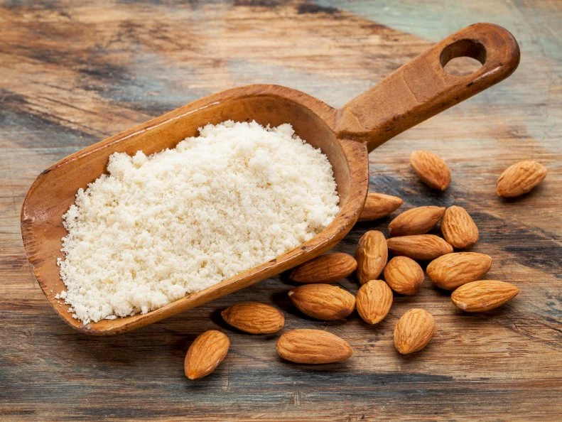 almond flour high in protein, low in carbohydrates, low in sugars and gluten free - a rustic wooden scoop on grained wood background
