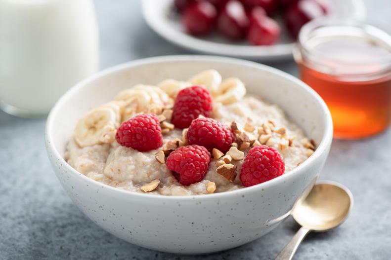Oatmeal porridge with raspberries and nuts in a bowl. Healthy vegan breakfast food