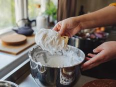 Close up shot of an anonymous young Caucasian woman making whipped cream on a kitchen counter at home