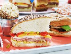 Muffulettas are a New Orleans specialty sandwich, packed with sliced cheeses, hard meats and olive salad. I thought it would be fun to do my Low Country spin on this favorite sandwich of mine, replacing the olive salad with my chow chow and pimientos and adding some saut&eacute;ed smoked sausage and onions to the mix. The great thing about this sandwich? The longer it sets, the better it gets!