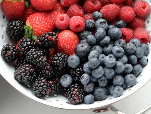 raspberries, blueberries, strawberries and blackberries in colander