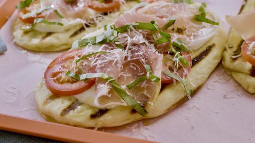 https://food.fnr.sndimg.com/content/dam/images/food/fullset/2022/08/25/MW1105-molly-yeh-margherita-and-prosciutto-pizzettes_4x3.jpg.rend.hgtvcom.511.288.suffix/1661454378311.jpeg