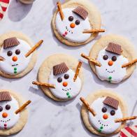 Description: Food Network Kitchen's Marshmallow Fluff Topped Melting Snowman Cookies. Keywords: Peanut Butter Cups, Vanilla Extract, Flour, Egg, Marshmallow Fluff, M&Ms, Pretzel Sticks, Sprinkles.