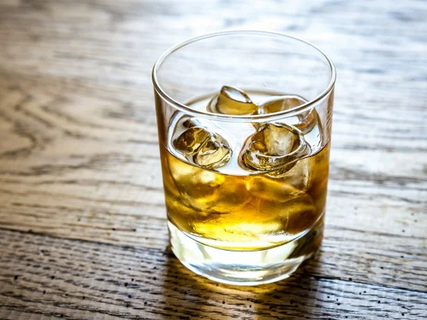 Glass of rum on the wooden background