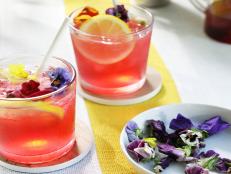 This drink is not only delicious, it happens to be gorgeous, too! The pink hue comes from the hibiscus tea-infused simple syrup and a garnish of edible flowers. A lemon wheel makes it even prettier.