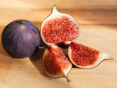 Fresh figs, whole and sliced on a light wood