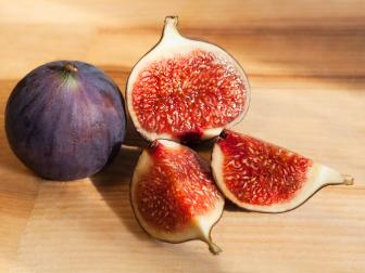 Fresh figs, whole and sliced on a light wood
