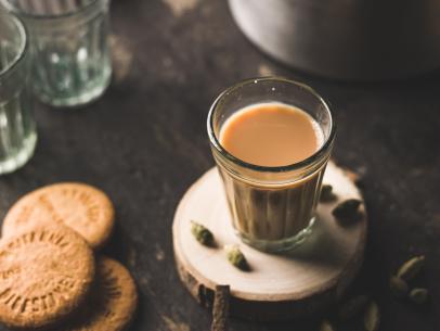 Indian chai in glass cups with metal kettle and other masalas to