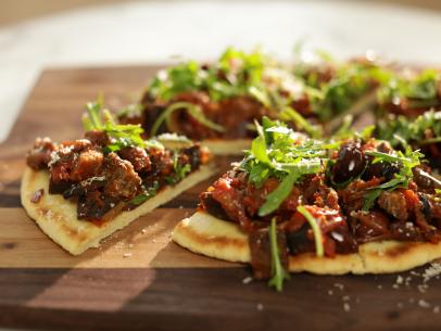 Close-up, side on caponata pizza on wooden chopping board, as seen on Mary McCartney Serves It Up, season 3.