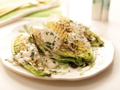 Close-up, grilled lettuce with dressing on white plate on white background, as seen on Mary McCartney Serves It Up, season 3.