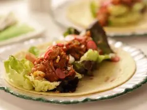 Close-up, BBQ jackfruit wraps on white plates, set table, as seen on Mary McCartney Serves It Up, season 3.