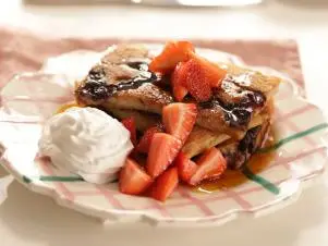 Portrait close-up of pancakes with strawberries and cream, as seen on Mary McCartney Serves It Up, season 3.