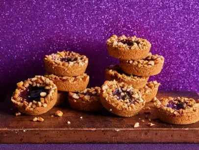 Description: Food Network Kitchen's Peanut Butter Jammies. Keywords: Peanut Butter, Sugar, Brown Sugar, Egg, Vanilla Extract, Grape Jam, Roasted Peanuts