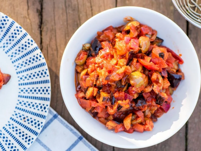 ricetta tipica siciliana a base di melanzane fritte, con aceto, zucchero e salsa di pomodoro