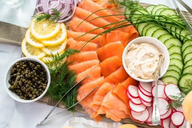 Bagel brunch board with smoked salmon and fresh vegetables.