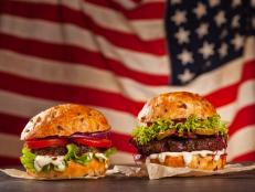 Delicious hamburgers served on wooden planks. Flag of USA as background