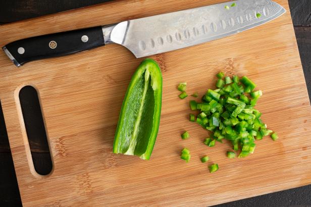 Minced green chili pepper on a wooden chopping board