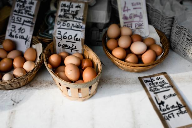 Brown eggs in pleated baskets with written prices in french.