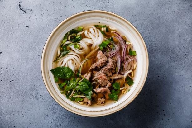 Pho Bo vietnamese Soup with beef in bowl on concrete background