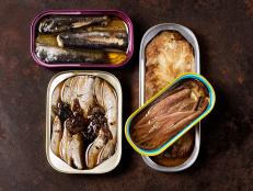 Opened cans of fish on a metal rustic background