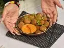 3/4 of Kenya T. Parham’s hands holding Crispy Akara, as seen on The Kwanzaa Menu.