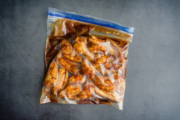 Uncooked chicken wings and marinade in a ziplock bag