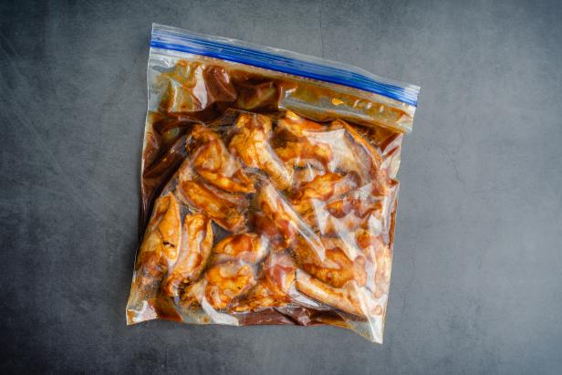 Uncooked chicken wings and marinade in a ziplock bag