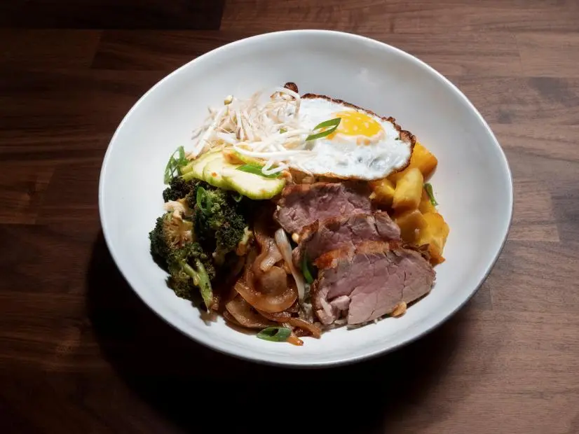 Anne Burrell’s Marinated Pork Tenderloin on Coconut Lime Rice with a Fried Egg is displayed, as seen on Worst Cooks in America, Season 25.