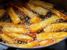 French fries fry in hot bubbling oil in a frying pan