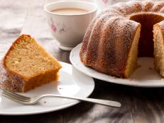 Slice of yogurt bundt cake served with a cup of coffee with milk