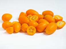 A handful of fresh kumquats with some of them halved