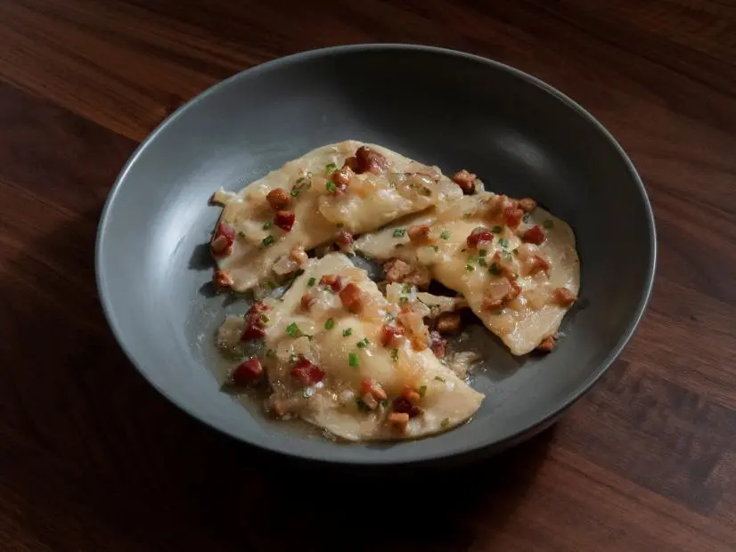 Anne Burrell’s Potato and Cheddar Pierogi with Pancetta and Onion Sauce are displayed, as seen on Worst Cooks in America, Season 25.