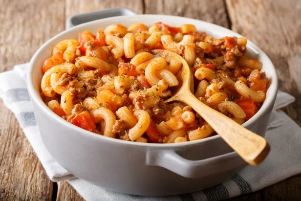 american chop suey, american goulash, with elbow pasta, beef and tomatoes close-up in a saucepan. Horizontal
