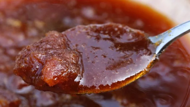 Close up of date molasses with silver spoon