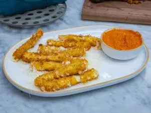 Host Selena Gomez and Chef Alex Guarnascelli's dish "Mozzarella Sticks with Creamy Tomato Sauce", as seen on Selena + Chef: Home for the Holidays, Season 5.