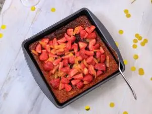 Host Selena Gomez and Chef Eric Adjepong's final dish "Malva Pudding with macerated strawberries and dried apricots", as seen on Selena + Chef: Home for the Holidays, Season 5.
