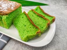 Slices of Bolu Pandan or Sponge Cake or Chiffon Cake served on white plate. Sweet fluffy dessert or snack. Selective focus image
