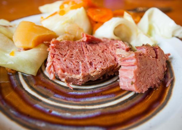 corned beef with a side of carrots, cabbage, potatoes, and onion.